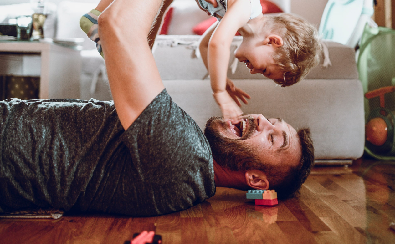 Dad playing with child on floor